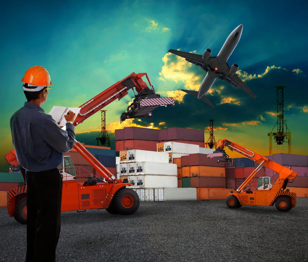 working man in logistic business working in container shipping yard with dusky sky and jet plane cargo flying above use for land to air transport and freight